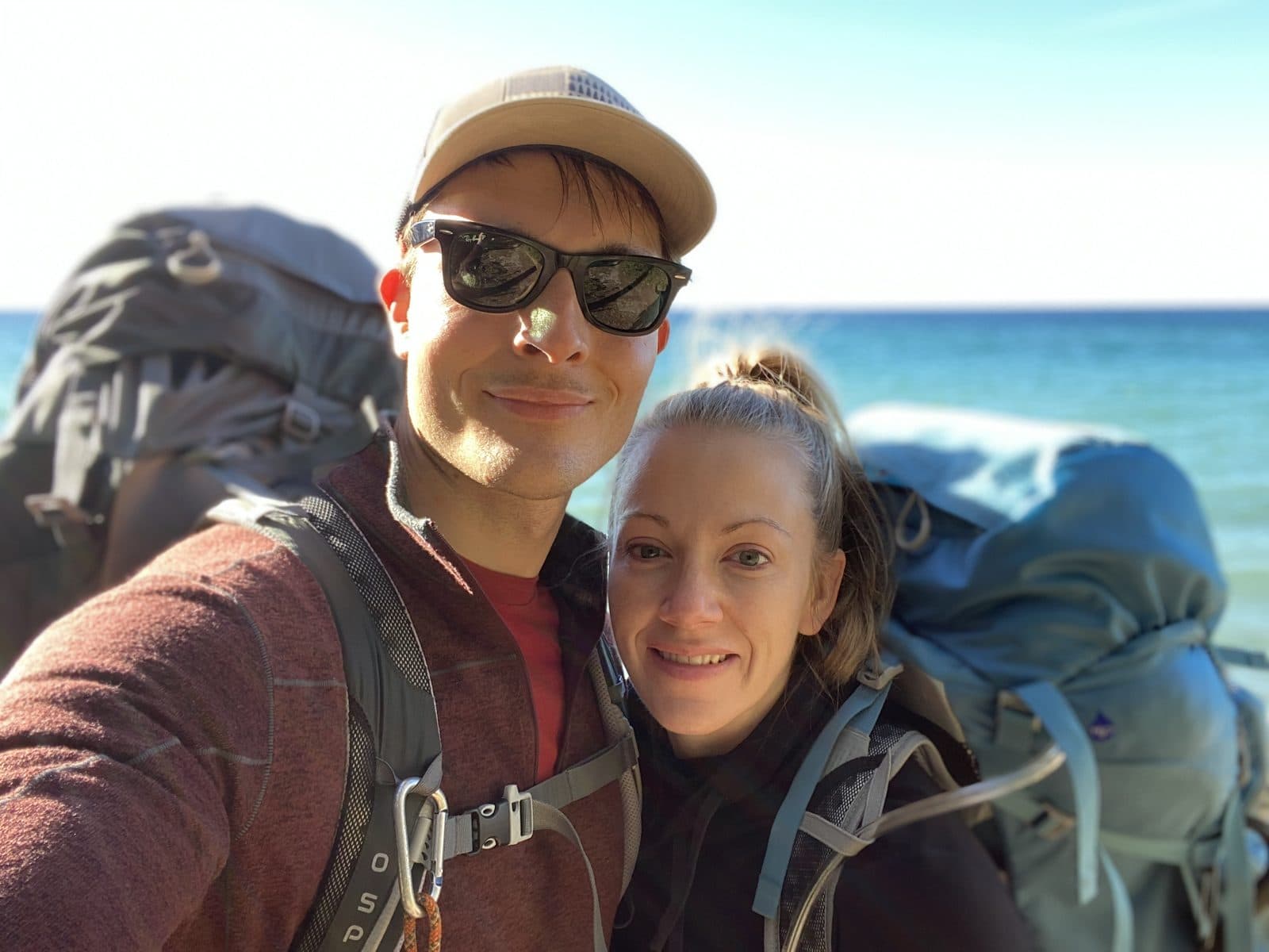 Justin and Christie Smith backpacking along a lakeshore